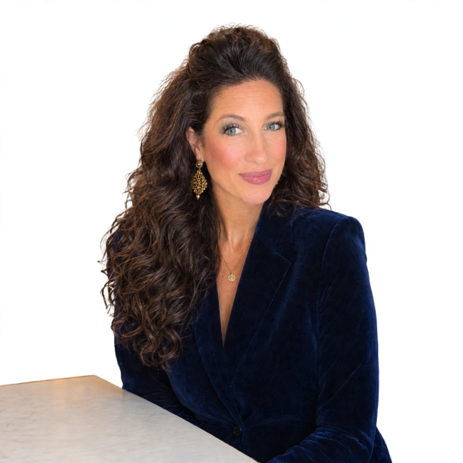 Heather Adams in a navy velvet blazer against a clean white background